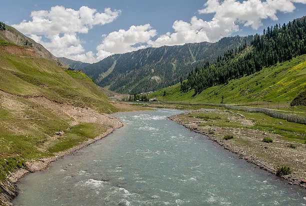Turquoise Kishanganga River flowing through green alpine meadows of Gurez
