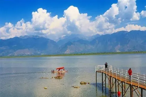 Watlab pier extending into Wular Lake with speedboats