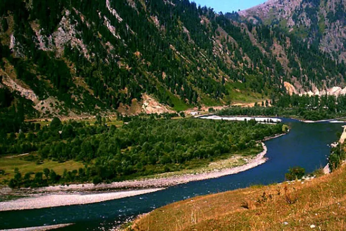 Deep blue Kishanganga River curving through mountain gorge in Keran