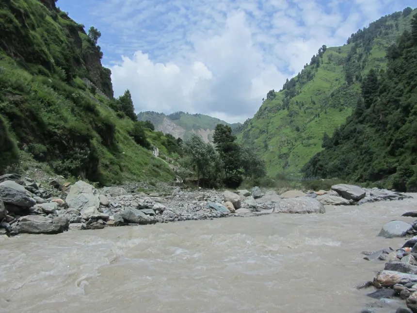 Rushing Ans mountain river flowing through forested V-shaped gorge