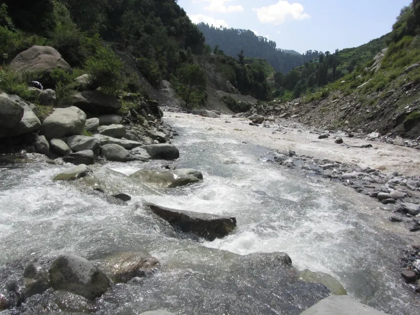 Fast flowing mountain stream cascading over large smooth boulders