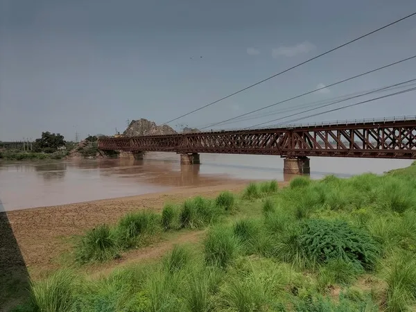 Steel truss girder railway bridge crossing broad riverbed