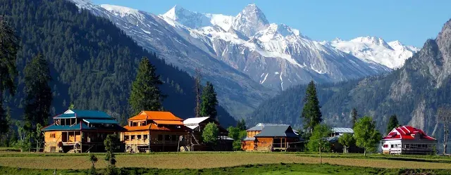 Traditional alpine wooden chalets under soaring snow peaks